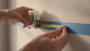 Measuring a wall with a tape and painter's tape mark